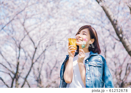 花見団子とビールを持つ女性 61252678