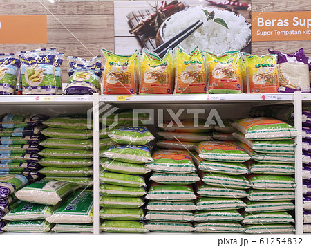 The rice in the plastic packaging is stacked and displayed on the rack inside the supermarket for sale. Variety of type and price. Sorted by brands. The rice in the plastic packaging is stacked and displayed on the rack inside the supermarket for sale. Variety of type and price. Sorted by brands. 61254832