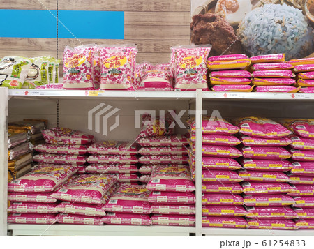 The rice in the plastic packaging is stacked and displayed on the rack inside the supermarket for sale. Variety of type and price. Sorted by brands.  61254833