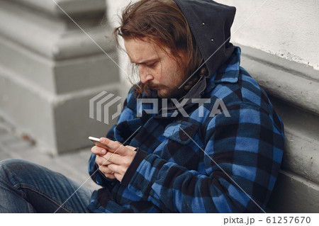 Homeless man in a durty clothes autumn city 61257670