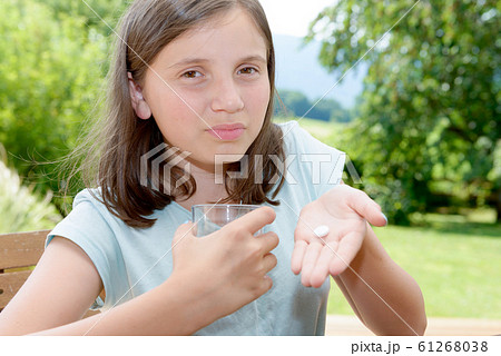 cute girl child taking pill with glass of water cute girl child taking pill with glass of water 61268038
