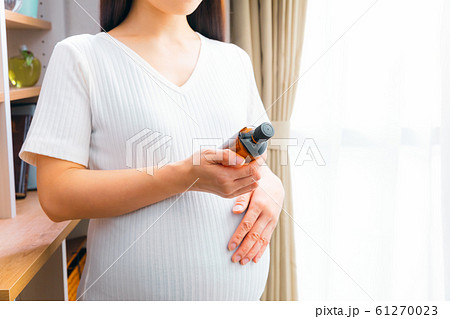 オイルを持つ妊婦 61270023