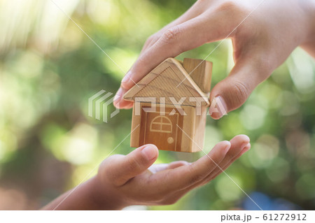 hand is giving a model of a house to child's hand, 61272912