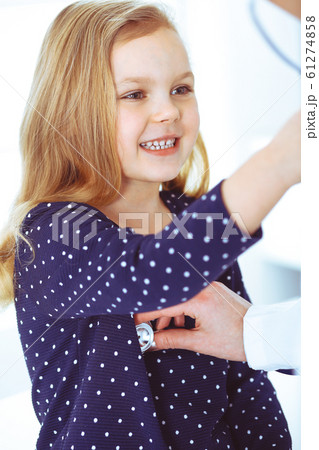 Doctor examining a child patient by stethoscope. Cute baby girl at physician appointment. Medicine concept. Toned photo Doctor examining a child patient by stethoscope. Cute baby girl at physician appointment. Medicine concept. Toned photo 61274858