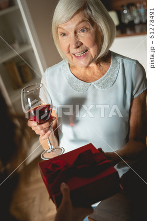 Happy mature female person taking gift box Happy mature female person taking gift box 61278491