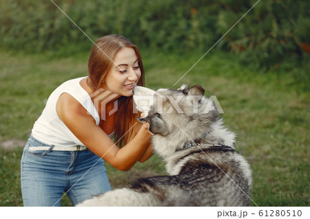 Girl in a spring park playing with cute dog Girl in a spring park playing with cute dog 61280510
