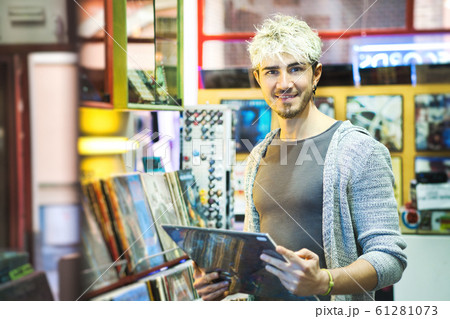 Young Man Choosing Vintage Vinyl LP In Records Shop Young Man Choosing Vintage Vinyl LP In Records Shop 61281073