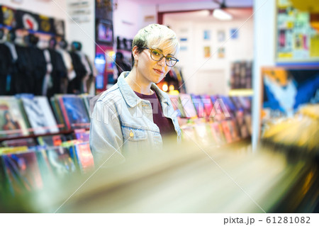 Young Woman Choosing Vintage Vinyl LP In Records Shop Young Woman Choosing Vintage Vinyl LP In Records Shop 61281082