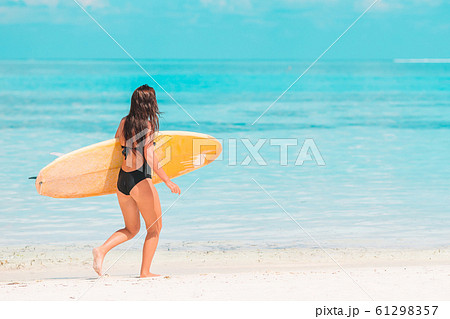 Beautiful surfer woman ready to surfing in turquoise sea, on stand up paddle board at exotic vacation 61298357