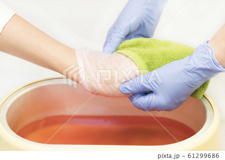 Process paraffin treatment of female hands in beauty salon  61299686