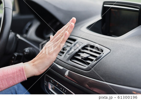 Woman hand on air conditioner ventilation grille in car Woman hand on air conditioner ventilation grille in car 61300196