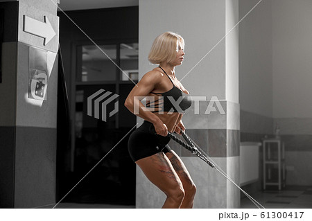 Female bodybuilder training back in gym. 61300417