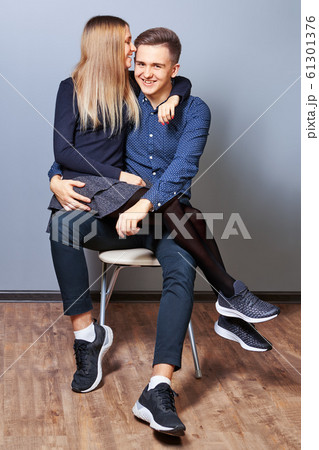 A nice young woman is sitting on her boys lap. A nice young woman is sitting on her boys lap. 61301376