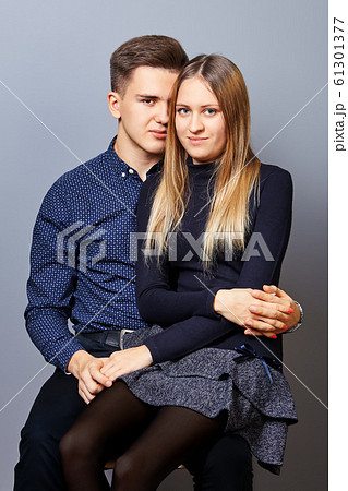 The guy put girl on his lap for a photoshoot. The guy put girl on his lap for a photoshoot. 61301377