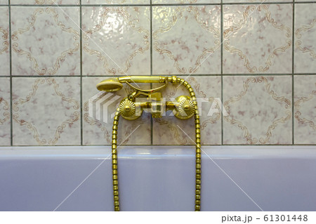Vintage gold bathtub faucet and ceramic tiles in background.Retro bronze look. antique design 61301448