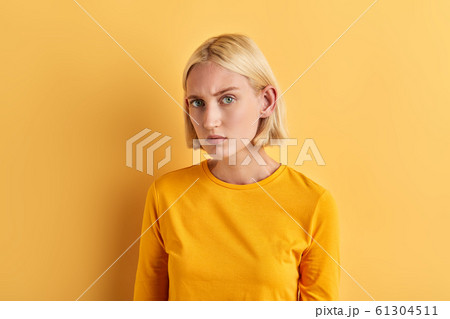serious skeptic woman in fashion yellow sweater posing to the camera serious skeptic woman in fashion yellow sweater posing to the camera 61304511