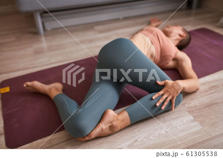 Young beautiful woman practice yoga at home on mat 61305538