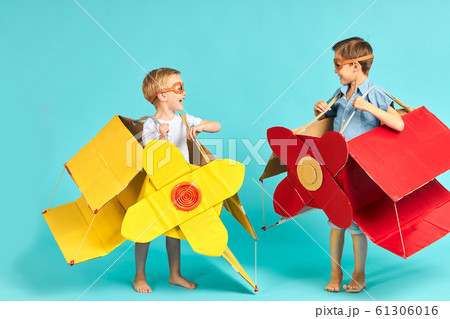 Cheerful kids wearing airplane boxes 61306016