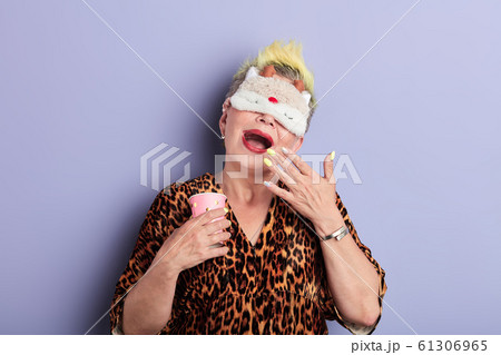 stylish sleepy senior woman in sleeping eye mask yawning isolated on blue stylish sleepy senior woman in sleeping eye mask yawning isolated on blue 61306965