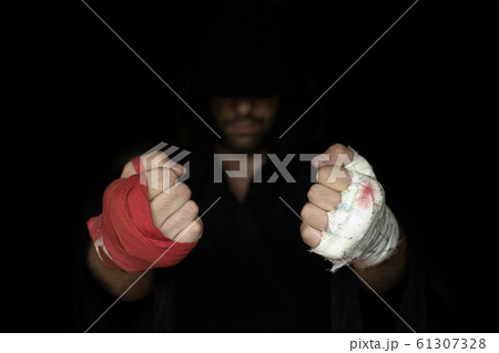 Different kinds of hands taping before rumble. Fists of pro boxer in hoodie, close up, low key, selected focus. 61307328
