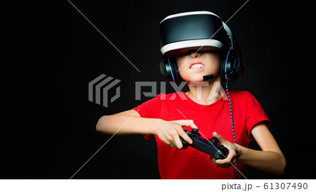A young girl in VR playing video games with excited face. Photo on dark background. 61307490