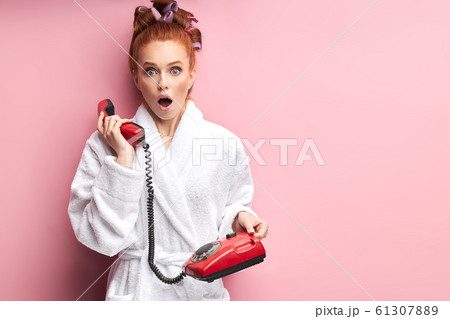 Portrait of beautiful young redhead girl wearing bathrobe stand talking on landline phone Portrait of beautiful young redhead girl wearing bathrobe stand talking on landline phone 61307889