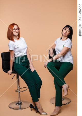 Two colleagues sitting on bar stools. Two pretty 61308277