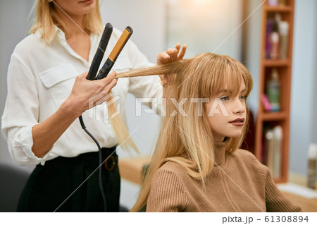 modern hairdresser doing her work in beauty saloon 61308894