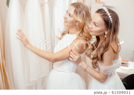 young caucasian girlfriends dream about and choosing wedding dress 61309031