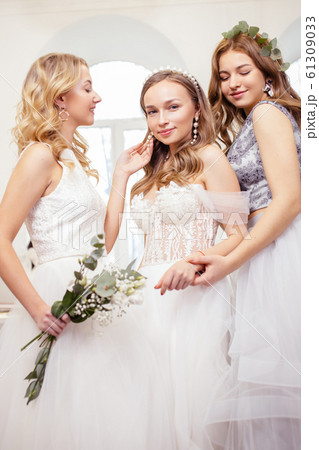 three caucasian girlfriends try on wedding dresses 61309033