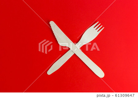 Wooden disposable fork and knife on red background, recycling and eco friendly concept. Zero waste, plastic free items, stop plastic. Top view. Eco cutlery from pine wood. Wooden disposable fork and knife on red background, recycling and eco friendly concept. Zero waste, plastic free items, stop plastic. Top view. Eco cutlery from pine wood. 61309647