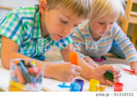 Kids painting with different materials on large canva on the flour 61310552