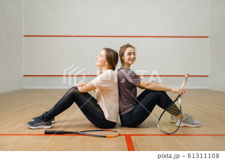 Players with squash rackets sits back to back Players with squash rackets sits back to back 61311108