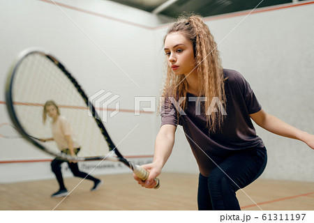 Two players with squash racket playing on court 61311197