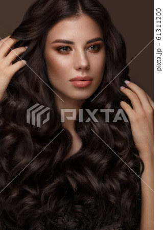 Beautiful brunette model: curls, classic makeup and full lips. The beauty face. Beautiful brunette model: curls, classic makeup and full lips. The beauty face. 61311200