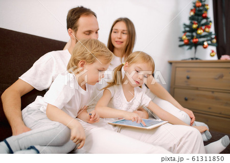 caucasian family use tablet at home sitting on sofa caucasian family use tablet at home sitting on sofa 61311850