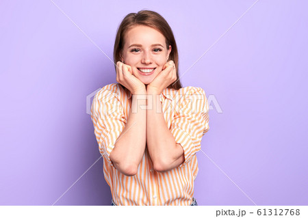 Studio shot of young pretty girl smiling happily, gazing in camera Studio shot of young pretty girl smiling happily, gazing in camera 61312768