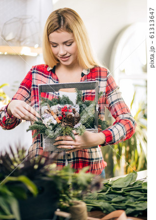 pretty young blond female making fashion modern bouquet of different flowers pretty young blond female making fashion modern bouquet of different flowers 61313647
