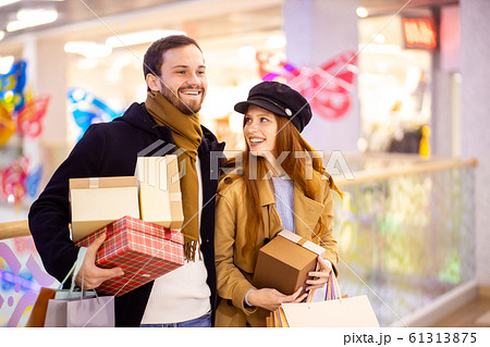 beautiful caucasian couple after shopping holding gifts in mall beautiful caucasian couple after shopping holding gifts in mall 61313875