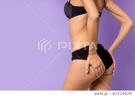 side view on lower part of body of young woman isolated over purple background side view on lower part of body of young woman isolated over purple background 61314029