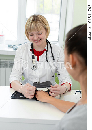 Physiotherapist puts on a medical tonometer to 61314703