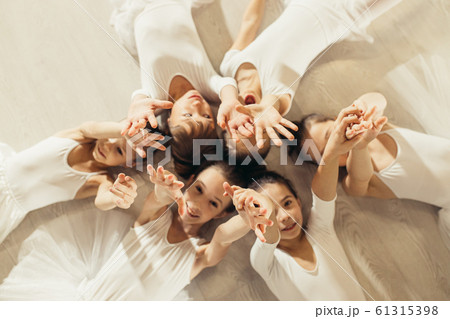 friendly little ballet dancers lying on floor in circle 61315398