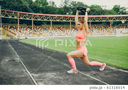 The girl at the stadium is playing sports 61316014