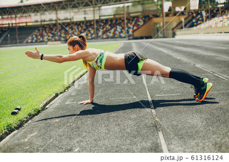 The girl at the stadium is playing sports 61316124