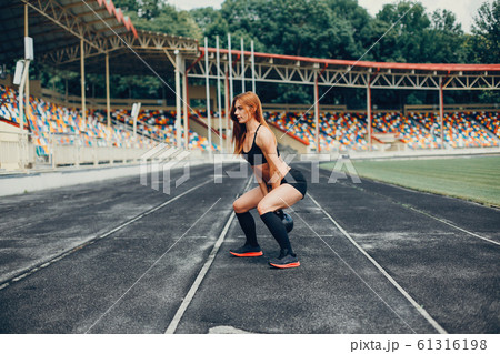 The girl at the stadium is playing sports 61316198