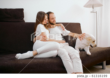 adorable caucasian couple sit on sofa with dog 61316199