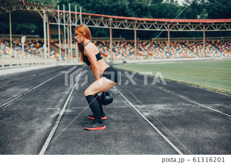 The girl at the stadium is playing sports 61316201