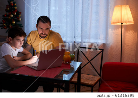 kid boy studying at home before new year holidays kid boy studying at home before new year holidays 61316399