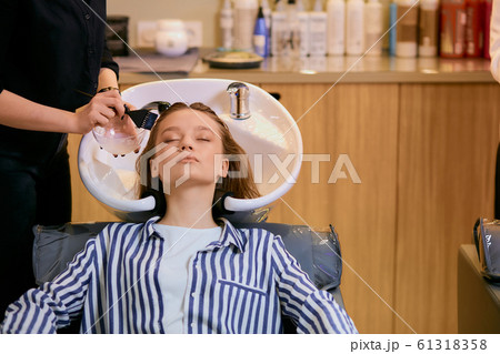 young woman dyeing hair in beauty saloon young woman dyeing hair in beauty saloon 61318358