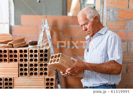 Man checking brick for masonry 61319995